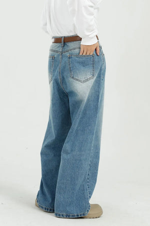 Wide-leg denim jeans in medium wash with pockets, styled casually.