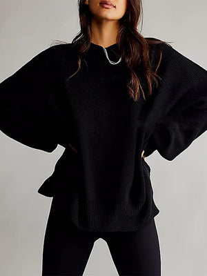 Black oversized ribbed knit sweater with drop shoulders and wide sleeves.