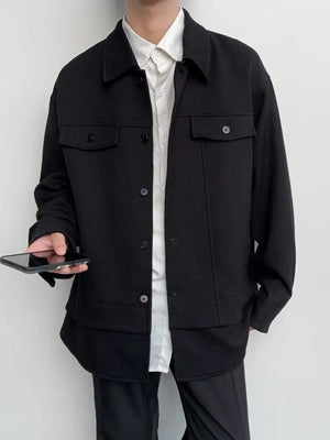 Black oversized button-down jacket with dual chest pockets and button closure.