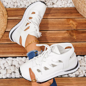 Chic white round toe lace-up sneakers with cut-out details and a gold ankle bracelet.