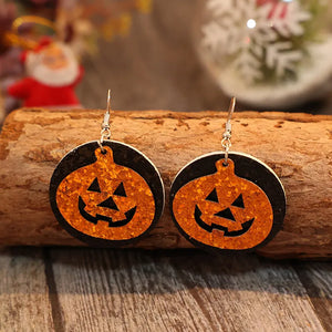 Glitter pumpkin Halloween dangle earrings in tangerine with black backing.