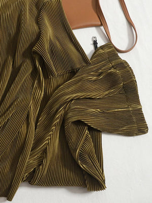 Olive green pleated two-piece set with wide sleeves and a brown crossbody bag.