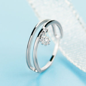 Elegant double layered sterling silver ring with a dangling charm and cubic zirconia stone.