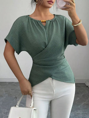 Green short sleeve maternity blouse with beaded keyhole neckline and wrap detail