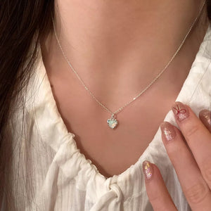 Dainty silver heart pendant necklace with opal detail on a delicate chain.