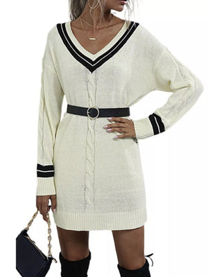 Beige V-neck cable knit sweater dress with black stripe trim and a black belt.