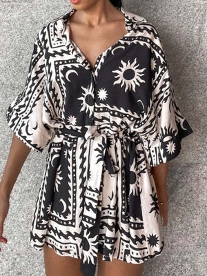 Black celestial print wrap romper with short sleeves and a tie waist.