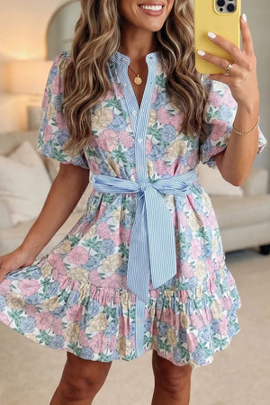 Floral mini dress with contrast trim, belted waist, button front, and ruffled hem.
