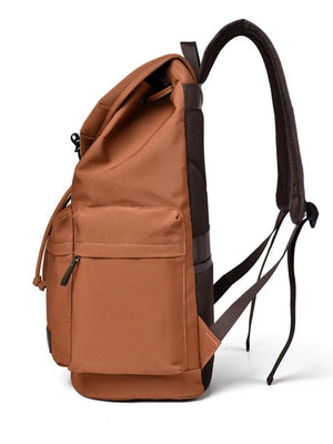 Ochre canvas backpack with brown leather accents and multiple pockets.