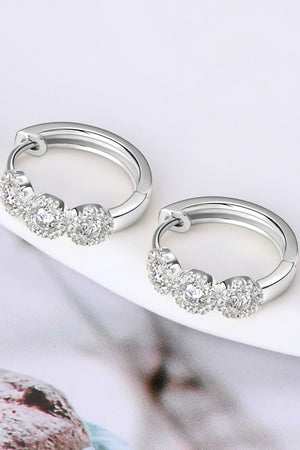 Silver triple cluster diamond huggie hoop earrings with three round cubic zirconia stones.