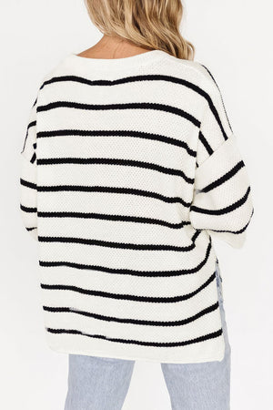 White and black striped knit pullover sweater with a crew neck and relaxed fit.
