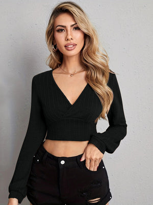Black textured wrap-front crop top with long sleeves and a deep V-neck.