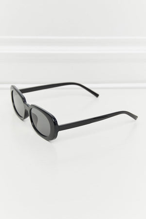 Black oval sunglasses with tortoiseshell sunset lenses and a sleek frame.