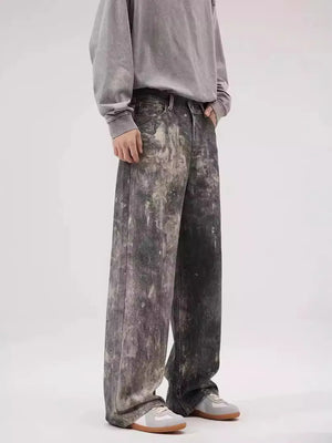 Dark gray wide-leg denim jeans with distressed paint-splatter effect and a relaxed fit.