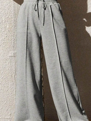 Gray sweatpants with drawstring and wide legs, featuring a relaxed fit and front seam detail.