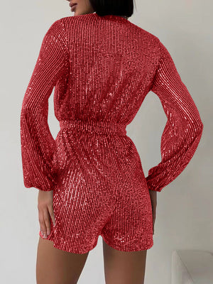 Sequin wrap romper in scarlet with blouson sleeves and elastic waist.