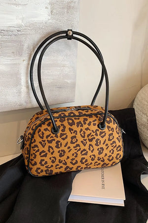 Caramel leopard print barrel bag with black handles and trim.