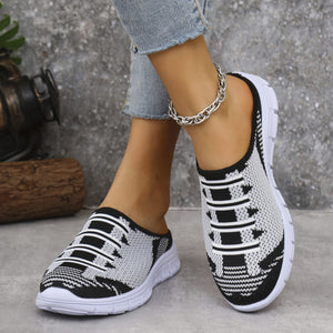 Sporty knit slip-on sneakers in black and white with a mule back and white soles.