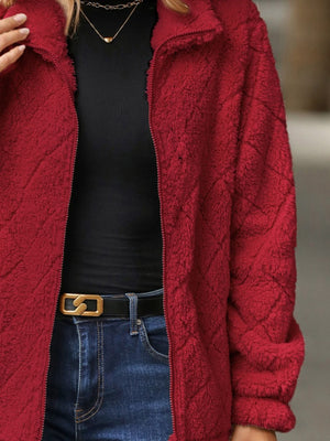 Deep Red textured teddy zip-up jacket with a diamond pattern, styled with a black top and jeans.