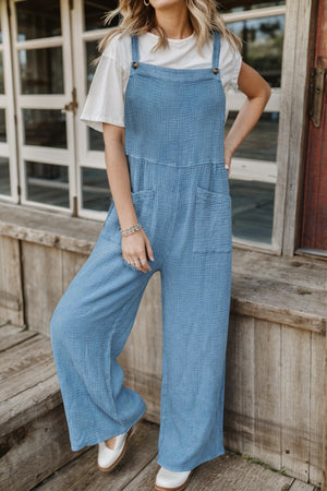 Light blue textured cotton overalls with square pockets and wide legs.
