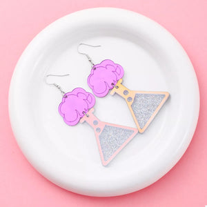 Fuchsia pink acrylic dangle earrings shaped like science beakers with glitter accents.