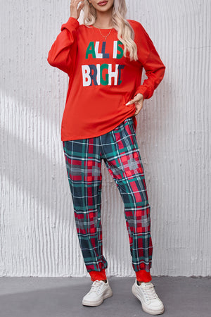 Red long sleeve top with "All Is Bright" graphic and plaid lounge pants.