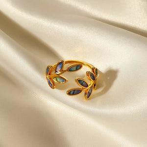 Gold bypass ring with leaf design and iridescent blue accents