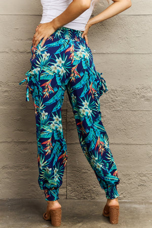 Tropical print cargo pants with gathered cuffs and tie details.
