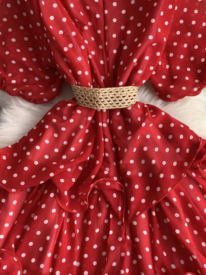 Red polka dot tiered dress with woven belt and ruffled hem.