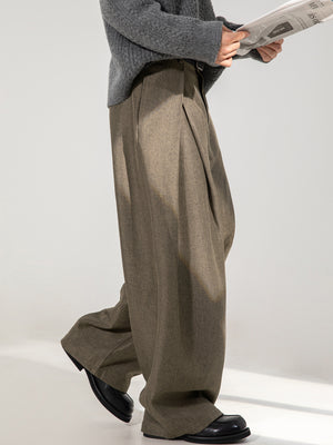 Men's brown wide-leg trousers with a relaxed fit and pleated front.
