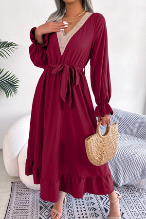 Wine midi dress with lace trim V-neck, tie waist, long sleeves, and ruffled hem.