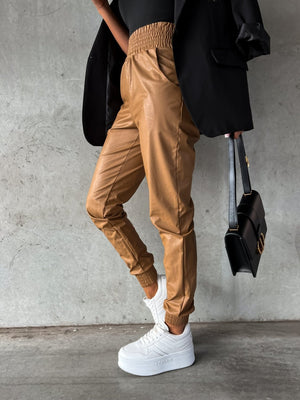 Brown leatherette gathered waist joggers with elastic cuffs and pockets.