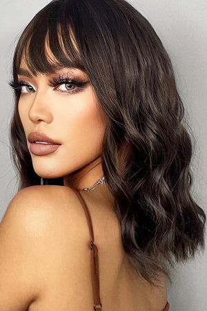 Textured black bob wig with fringe and subtle highlights, styled with soft waves.