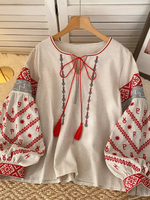 White embroidered folk shirt with tie neck and balloon sleeves.