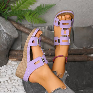Chic open-toe wedge sandals in purple with cutout details and gold accents.