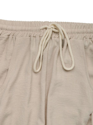 Tan palazzo trousers with drawstring waist and pockets.