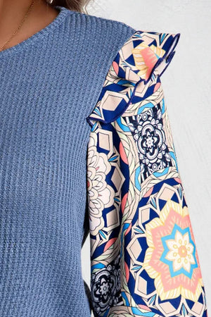 Dusty blue knit top with ruffled printed sleeves and a boho pattern.