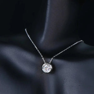 Silver solitaire bezel-set pendant necklace with a delicate chain.