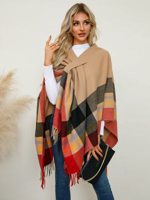 Asymmetric plaid fringe cape in tan with red, black, and yellow checks.