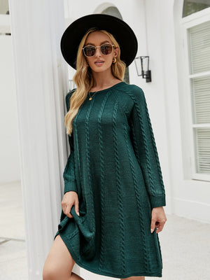 Green cable knit A-line sweater dress with long sleeves and crew neck.