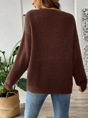 Chocolate knit sweater with off-shoulder neckline and ribbed texture.