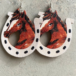 Wooden horseshoe earrings with horse head cutout and black dot detail.