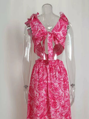 Pink paisley print V-neck maxi dress with ruffled shoulders and cut-out sides.
