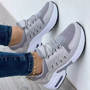Grey lace-up chunky platform sneakers with white soles and mesh details.