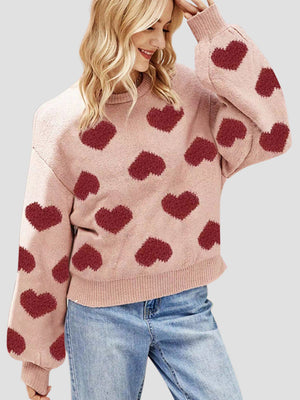 Watermelon pink knit sweater with allover heart motif and balloon sleeves.