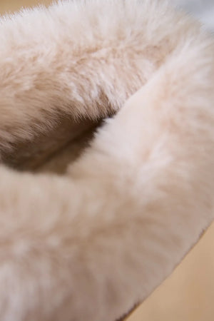 Suede house slippers with plush shearling trim in a light beige color.