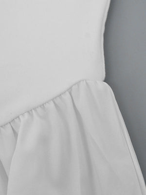 White flowy maxi dress with gathered ruffle detail at the waist.
