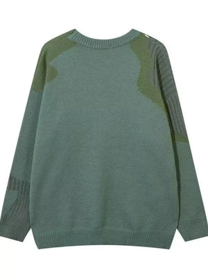 Men's green contrast knit sweater with abstract textured details and ribbed cuffs.