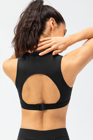 Black high-neck zip-front active crop top with back cutout and adjustable strap.