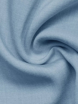 Light blue fabric detail of a buttoned vest and tailored shorts set.